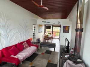 ein Wohnzimmer mit einem roten Sofa und einem Tisch in der Unterkunft Depto Maitencillo frente al Mar - Costamai in Maitencillo