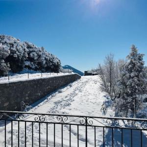 a snow covered path with a fence and a tree at Panorama in Arachova
