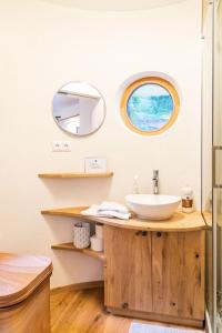 a bathroom with a sink and a mirror at WOHNWAGON Tiny Houses I in Gutenstein
