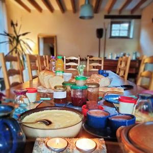 uma mesa com muitos frascos de comida em La Ferme de Plénoise Chambres d'hôtes 