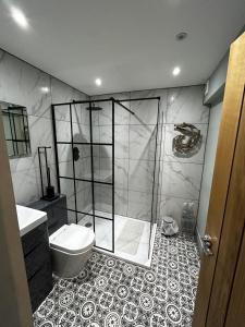 a bathroom with a shower and a toilet at Olívia Rojo in Cromer