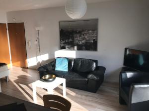 - un salon avec un canapé en cuir noir et une table dans l'établissement Apartment am Hochseilgarten, à Löhne