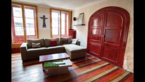 a living room with a couch and a red door at Cathédrale spacieux appartement in Strasbourg