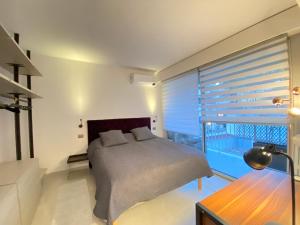 um quarto com uma cama e uma grande janela em Central, quiet & cosy apartment near Monaco em Beaulieu-sur-Mer