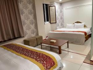 um quarto de hotel com duas camas e uma mesa em 土城飯店 em Tucheng