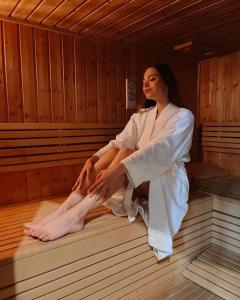 Uma mulher está sentada numa sauna. em Hostel Browar Jedlinka em Jedlina-Zdrój