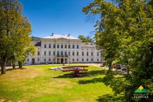 un grand bâtiment avec un parc en face dans l'établissement Hostel Browar Jedlinka, à Jedlina-Zdrój