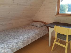 a small bedroom with a bed and a desk at Suurepera puhkekeskuse saunamaja 