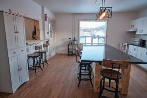 uma cozinha com mesa e cadeiras num quarto em AUBERGE DU DIMANCHE - Riviere-Eternite, Pres du Fjord-du-Saguenay et de l'Anse-Saint-Jean em Riviere Eternite