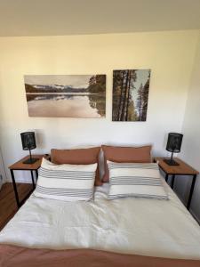 1 dormitorio con 1 cama con 2 lámparas en 2 mesas en Cabañas del lago en El Calafate