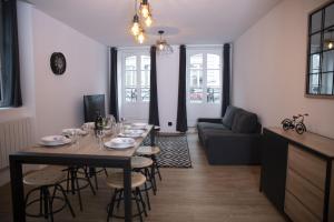 a dining room and living room with a table and chairs at Triplex 110 m2 centre historique avec jacuzzi DINAN in Dinan