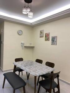 a room with a table and chairs and a clock on the wall at Emerald Avenue Apartment Madam Ng. in Cameron Highlands +7 photos