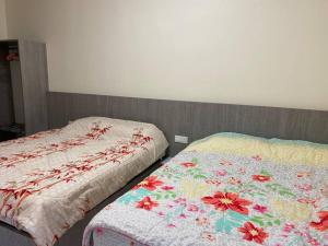 two beds sitting next to each other in a bedroom at Emerald Avenue Apartment Madam Ng. in Cameron Highlands