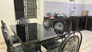 a kitchen with a microwave and a table and chairs at Muffys Villa in Arpora