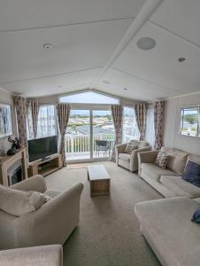 a living room with couches and a flat screen tv at BEAUTIFUL LUXURY Caravan HAVEN LITTLESEA STUNNING VIEWS Sleeps 6 in Weymouth