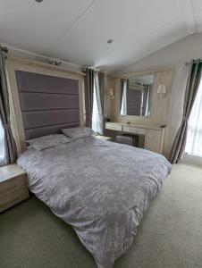 BEAUTIFUL LUXURY Caravan HAVEN LITTLESEA STUNNING VIEWS Sleeps 6 في ويماوث: غرفة نوم بسرير كبير في غرفة