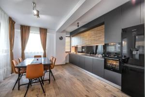 een keuken met een tafel en stoelen in een kamer bij Modern apartment with city-view near Poiana Brasov in Braşov
