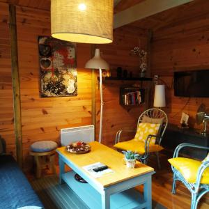 a living room with a table and yellow chairs at CHALET Chataigne ETAPEBOISEE in Fumay +10 photos