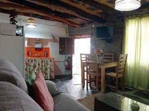 トレベレスにあるLa Abuela Mercedes en Trevélezのリビングルーム(ソファ、テーブル付)、キッチンが備わります。