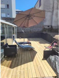 a patio with a chair and an umbrella at Chez Aurélie in Brest