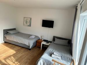 een slaapkamer met 2 bedden en een tv aan de muur bij Apartment am Kurpark in Bad Oeynhausen