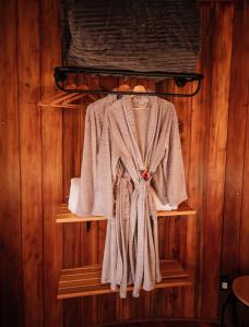 a robe on a shelf in a wooden wall at Pipas Terroir - Vale dos Vinhedos - Pousada Temática in Bento Gonçalves