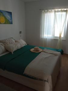 a bedroom with a bed with a hat on it at Apartments Tomić in Vodice