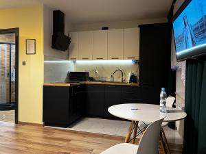 a kitchen with a table and a sink and a counter at Komfortowy Apartament w centrum in Jaworzno