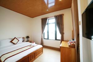 a bedroom with a large bed and a window at KB VILLA in Da Lat