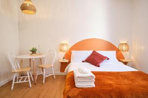 a bedroom with a bed and a table with chairs at AUBERGE DU DIMANCHE - Riviere-Eternite, Pres du Fjord-du-Saguenay et de l'Anse-Saint-Jean in Riviere Eternite