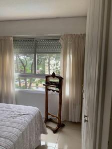1 dormitorio con cama y ventana en Apto con piscinas, servicios, cochera, wifi, en Punta del Este