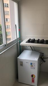 einen kleinen weißen Kühlschrank in einem Zimmer mit Fenster in der Unterkunft Lindo Apartamento Copacabana in Rio de Janeiro