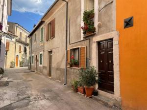 un callejón con un edificio con plantas y una puerta en Casa Italica - a quaint getaway in rural Italy, en Corfinio