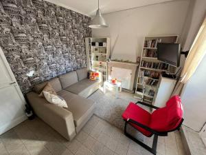 sala de estar con sofá y silla roja en Casa Italica - a quaint getaway in rural Italy, en Corfinio
