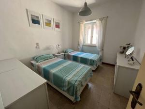 Habitación con 2 camas y mesa con espejo. en Casa Italica - a quaint getaway in rural Italy, en Corfinio