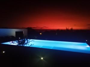 a lit up pool at night with a red sky at Villa Claire in Toliara