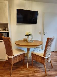 a dining room table with two chairs and a television at Sommerhaus Seidel - mit kostenlosem Parkplatz - in Stralsund