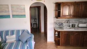 uma cozinha com um sofá e um lavatório num quarto em OASIS em Denia