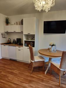 cocina y comedor con mesa y sillas en Sommerhaus Seidel - mit kostenlosem Parkplatz - en Stralsund