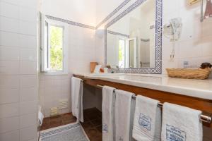 a bathroom with a sink and a mirror and towels at Quinta do Caracol in Tavira