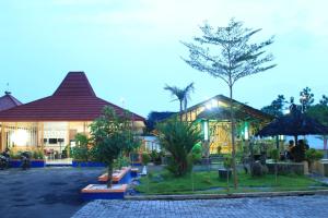 un edificio con un albero di fronte di Aluky Hotel a Majalengka