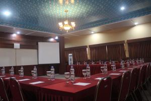 a conference room with a long table with wine glasses at Aluky Hotel in Majalengka