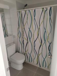 a bathroom with a toilet and a shower curtain at Depto Brisas del Valle in La Serena