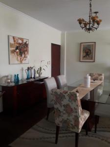 a dining room with a table and a chair at Apartamento Gonzaga Santos in Santos