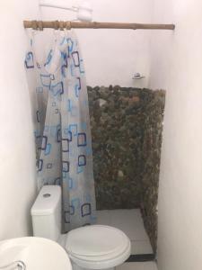 uma casa de banho com um WC e uma cortina de chuveiro em Hostel Itaparica em Itaparica