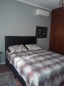 a bedroom with a black bed with a striped comforter at Apartamento Gonzaga Santos in Santos