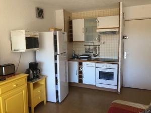 eine Küche mit weißen Geräten und einem weißen Kühlschrank in der Unterkunft Location Vacances entre mer et montagnes in Argelès-sur-Mer