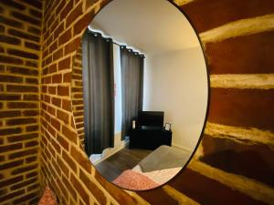 a mirror on a brick wall in a room at Le Studio 11 Abbeville centre baie de Somme in Abbeville
