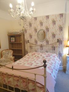 a bedroom with a bed and a chandelier at Private room near Roath Lake/Park in Cardiff