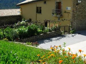 a garden with flowers in front of a house at Casa Mur A in Foradada de Toscar